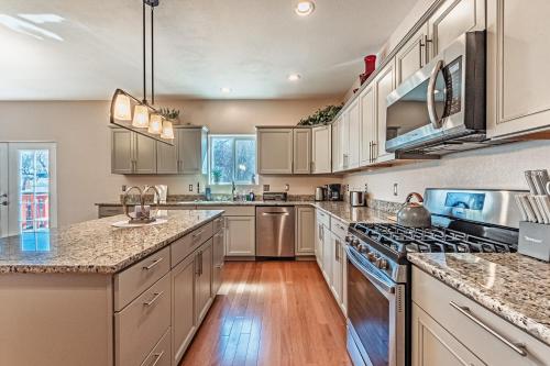 a large kitchen with stainless steel appliances and wood floors at Huge Cozy Home with Many Bedrooms in Ivywild in Colorado Springs