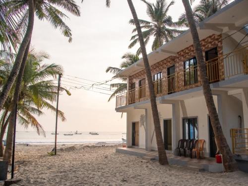 a house on the beach with palm trees at Malvan Beach Homestay in Malvan