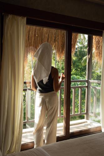 a woman is looking out of a window at Asgard Resort & MMA Gym in General Luna