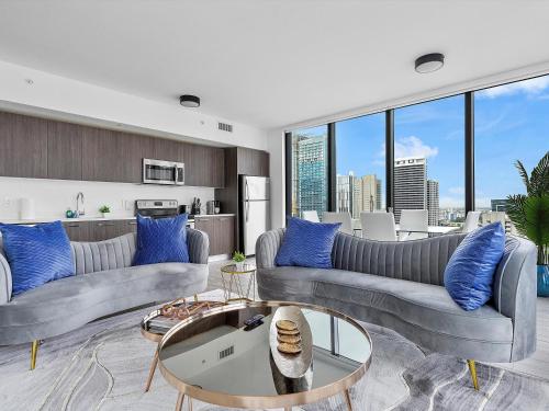 a living room with two couches and blue pillows at X Lounge V-Panoramic Private Residence in Miami