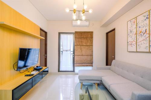 a living room with a couch and a tv at Elegant and Comfy 3BR Transpark Cibubur Apartment By Travelio in Depok