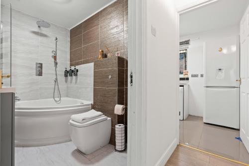 a bathroom with a tub and a toilet and a shower at Modern 2BR Apartment Near Canary Wharf Ideal for Business 02 Arena in London