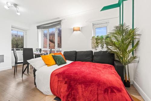 a bedroom with a bed with a red blanket at Modern 2BR Apartment Near Canary Wharf Ideal for Business 02 Arena in London
