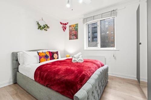 a bedroom with a large bed with a red blanket at Modern 2BR Apartment Near Canary Wharf Ideal for Business 02 Arena in London