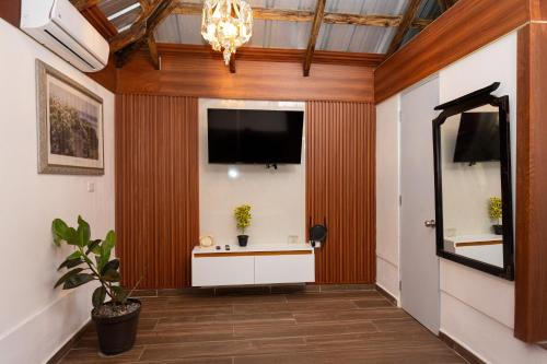 a hallway with a flat screen tv and a large mirror at Casa Palma El Limon Samana in El Limón