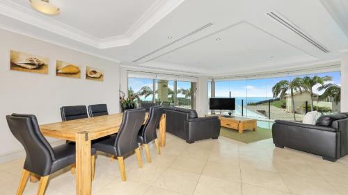 a dining room with a table and chairs and a television at Unit 13 - 3 Bedroom Ocean View in Terrigal