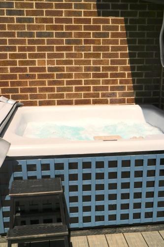 a bath tub sitting in front of a brick wall at Tranquility in the Meadows - 20 minutes to the City - 6 mins to the beach in Altona Meadows