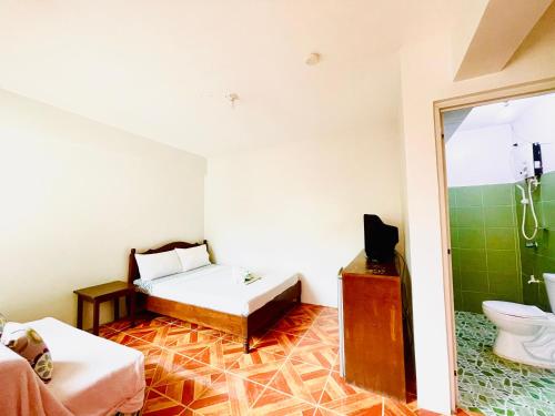 a room with a bed and a toilet in it at FIESTA HAUS RESORT in Boracay