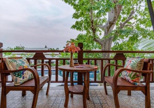 a table and chairs on a balcony with a view of the ocean at Lanna Deer Resort Chiang Mai in Chiang Mai