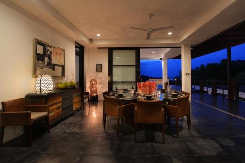 a dining room with a table and chairs with a view at Temple Hill Residence Villa in Jimbaran