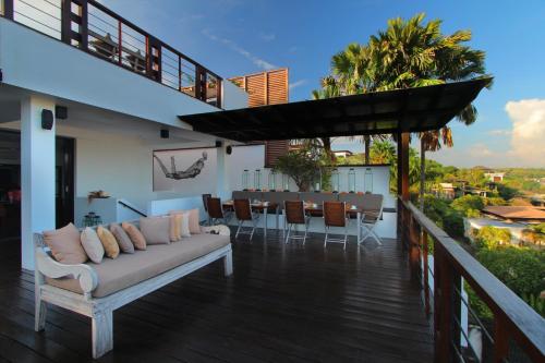 a balcony of a house with a couch and a table at Temple Hill Residence Villa in Jimbaran