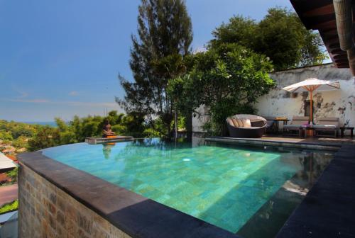 a swimming pool in a villa with a view of the ocean at Temple Hill Residence Villa in Jimbaran