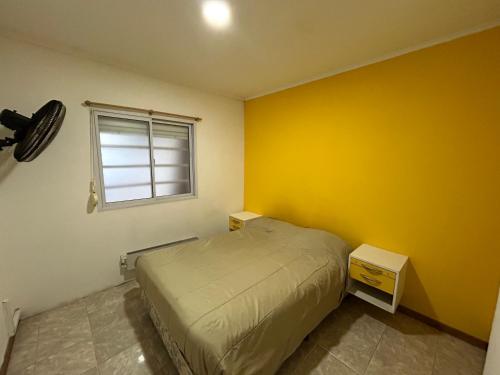 Un dormitorio pequeño con una cama y una ventana. en Casa de barrio, en Monte Hermoso