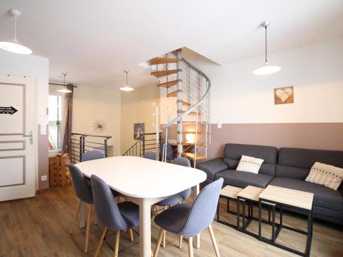 un salon avec une table, des chaises et un canapé dans l'établissement Triplex au 1er étage, 250 m des Thermes, proche commerces, WIFI, max. 6 pers., sans ascenseur - FR-1-415-107, à Le Mont-Dore