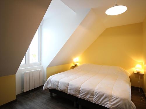 une chambre avec un lit blanc dans un grenier dans l'établissement Triplex au 1er étage, 250 m des Thermes, proche commerces, WIFI, max. 6 pers., sans ascenseur - FR-1-415-107, à Le Mont-Dore