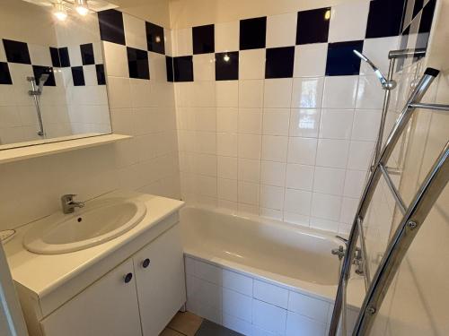 une salle de bain avec un lavabo et une baignoire dans l'établissement Appartement T2 avec piscine à Biscarrosse Bourg, proche plages du lac et océan, 4 pers, centre-ville - FR-1-319-454, à Biscarrosse