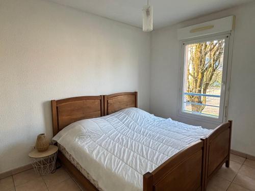 une chambre avec un lit et une fenêtre dans l'établissement Appartement T2 avec piscine à Biscarrosse Bourg, proche plages du lac et océan, 4 pers, centre-ville - FR-1-319-454, à Biscarrosse