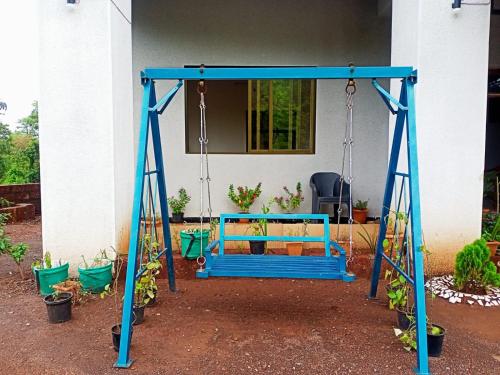 a swing bed in front of a house at Hotel Kavijay Sea View in Dapoli