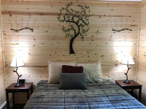 a bedroom with a tree mural on the wall at Susitna River Lodging, Backwoods Cabins in Talkeetna