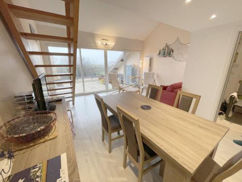 une salle à manger avec une table et des chaises en bois dans l'établissement Duplex T4 rénové à Arzon, 5 pers, proche plage - FR-1-775-19, à Arzon