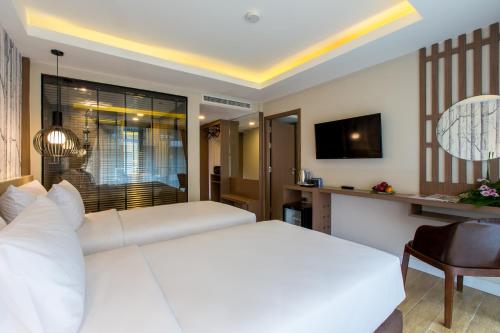a bedroom with a large white bed and a television at GLOW Ao Nang Krabi in Ao Nang Beach
