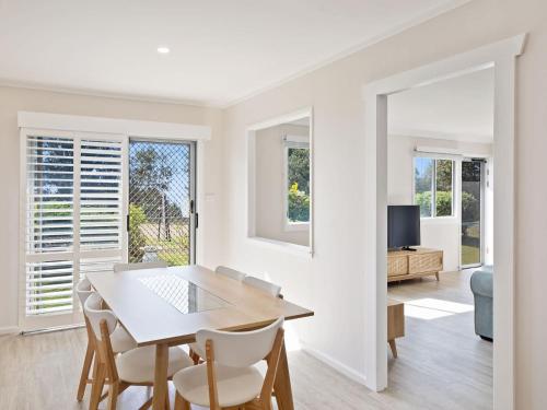 Marg's - Oceanstays - Oceanfront في Brooms Head: غرفة طعام بيضاء مع طاولة وكراسي