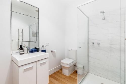 ローンにあるMinty's Beach Houseのトイレとシャワー付きの白いバスルーム