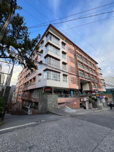 a large apartment building on the side of a street at Oyasumi Condotel with balcony-Megatowers 1 Near Session, SM, Burnham park, Baguio City in Baguio