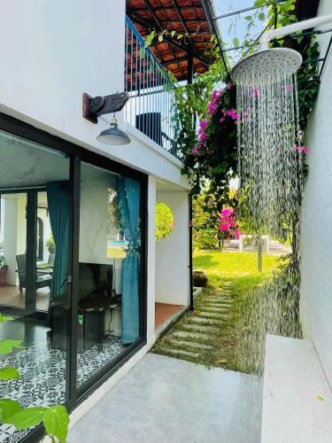 a house with a garden with a waterfall at La Y Riverview in Hue
