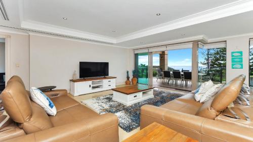 a living room with a couch and a television at Unit 18 - 3 Bed Part Ocean View in Terrigal