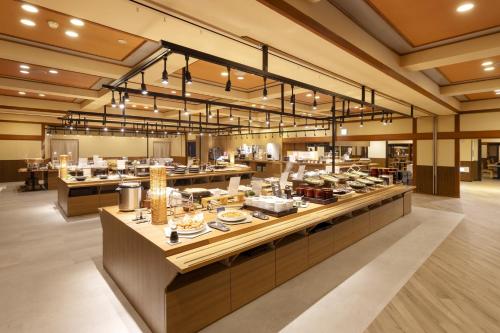 a restaurant with a buffet line with food on display at Ooedo Onsen Monogatari Premium Kaga Maruya in Kaga