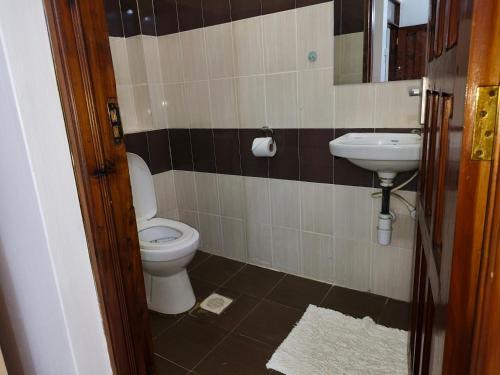 a bathroom with a toilet and a sink at NimKai Gold Place in Mtwapa