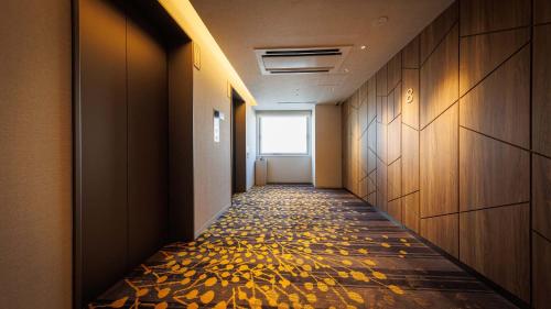 a corridor of a hallway with leaves on the floor at JR-East Hotel Mets Tachikawa in Tachikawa