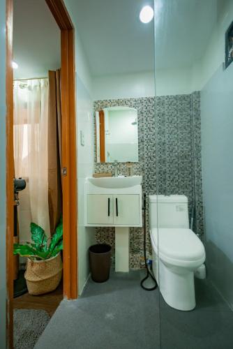 a bathroom with a toilet and a sink and a mirror at Upper Bliss Homestay in El Nido