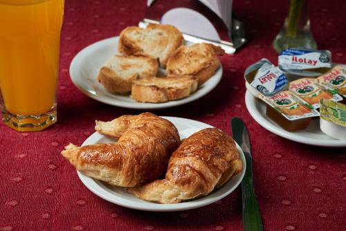 dois pratos de croissants e pão numa mesa em Blanro Hotel em Buenos Aires