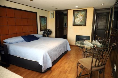 a bedroom with a bed and a table and a fireplace at Casa de Huéspedes en Satélite - Boutique Rosas in Mexico City