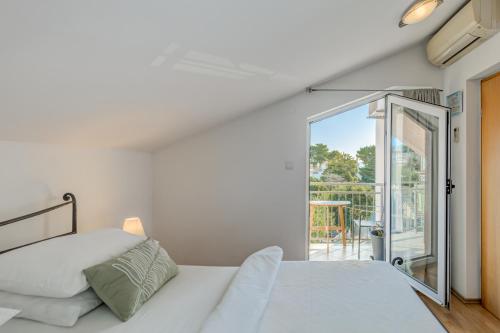 a bedroom with a bed and a balcony at Pink Inn in Podstrana