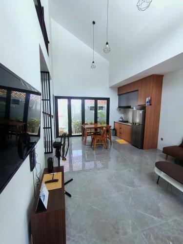 a living room with a table and a kitchen at Homestay Jogja Simply Homy Unit Jambon in Jetis