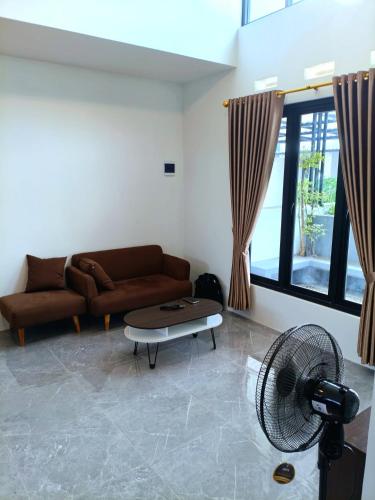 a living room with a couch and a fan at Homestay Jogja Simply Homy Unit Jambon in Jetis