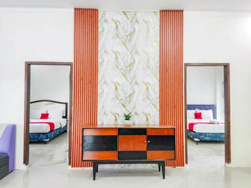 a room with two beds and a dresser and two mirrors at RedDoorz Syariah near Pengadilan Agama Wonosobo in Wonosobo
