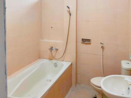 a bathroom with a tub and a toilet and a sink at RedDoorz Syariah near Pengadilan Agama Wonosobo in Wonosobo
