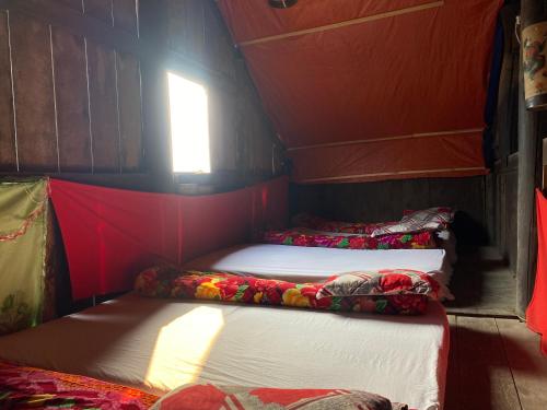 a small room with three beds in it with a window at Soi Local Guest House in Sa Pa