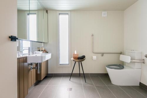 a bathroom with a toilet and a sink at Parklands Country Gardens & Lodges Blue Mountains in Blackheath