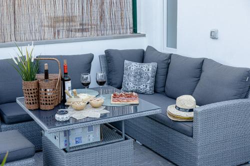a blue couch with a table with food and wine glasses at Bambú Suites Vegueta Alquiler por Habitación in Las Palmas de Gran Canaria