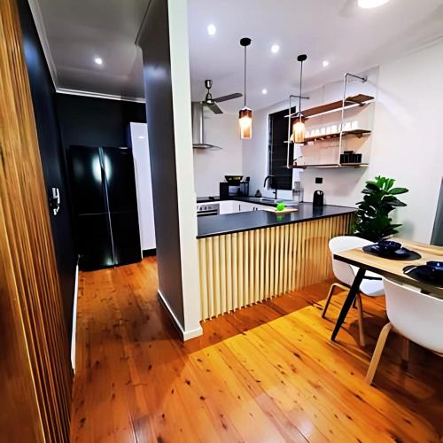 a kitchen and living room with a table and a dining room at 4 BDR Airconditioned Tropical Escape, Lap Pool & Parking for Caravans, Boats and Trailers in Casuarina