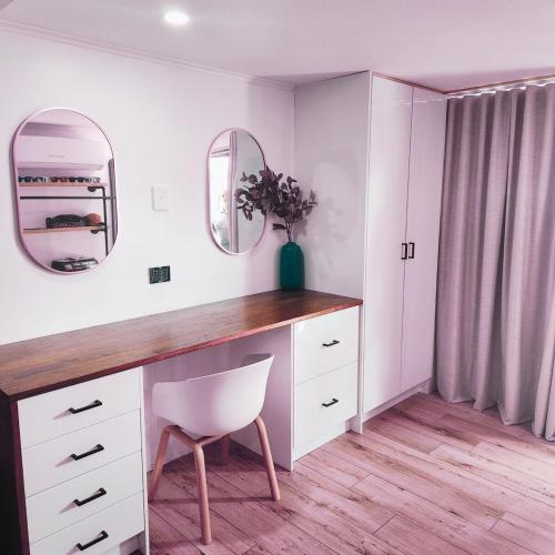 a room with a desk with a chair and a mirror at 4 BDR Airconditioned Tropical Escape, Lap Pool & Parking for Caravans, Boats and Trailers in Casuarina