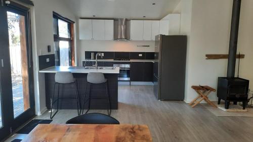 a kitchen with a refrigerator and a table and a stove at Tucked Away Chalet - Stunning Bathroom in Kingscote