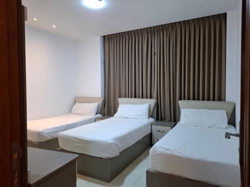 a hotel room with two beds and a window at مراسيم للشقق الفندقية in Amman