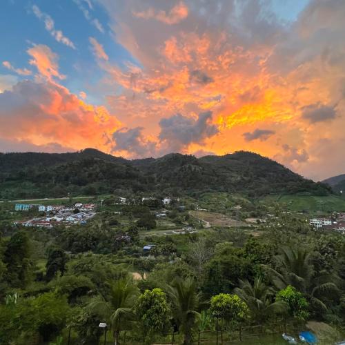 a sunset over a city with trees and mountains at The woodland at Selesa Hillhomes Bukit Tinggi Bentong in Bentong