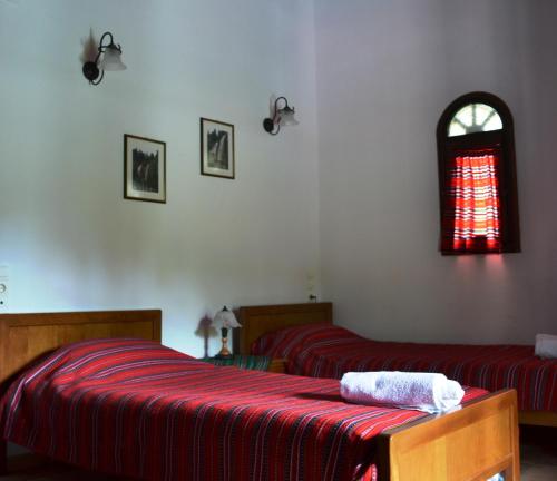 a bedroom with two beds and a window at Ξενώνας Αλώνι-Guesthouse Aloni in Theodoriana